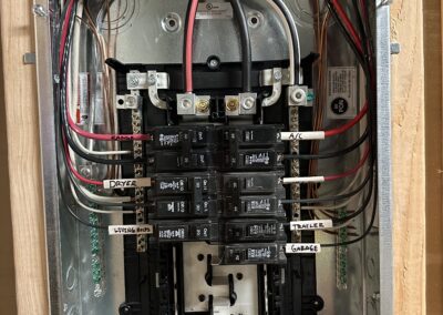 Electrical panel with multiple circuit breakers labeled for various areas like dryer, A/C, and garage. A screwdriver is placed at the bottom.